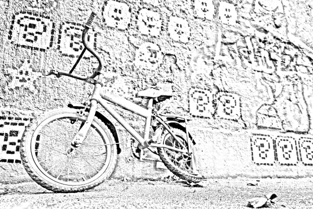 Grey sketch of a small red bicycle in front of a textured wall: the bicycle has clear shading, and the wall is a fine grey texture