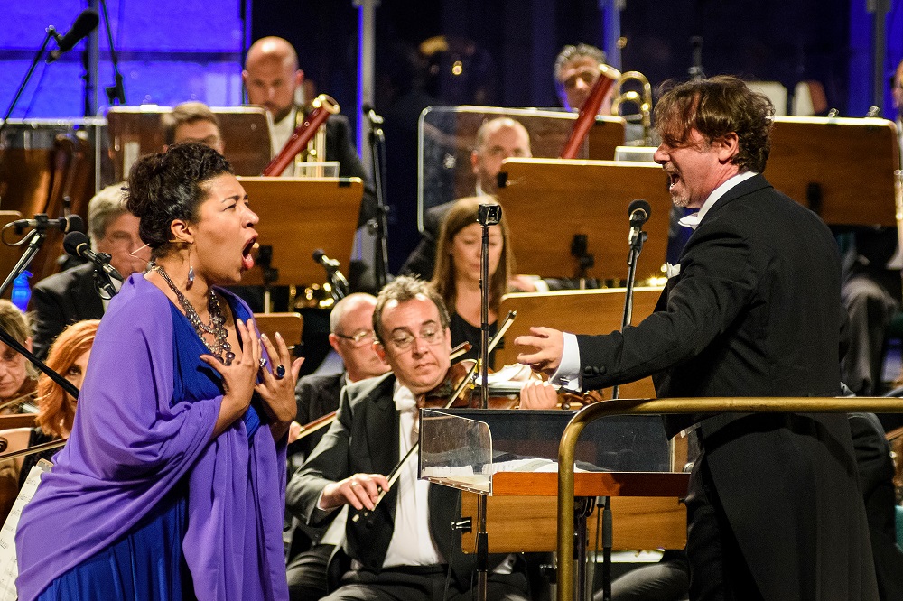 Opera singer and conductor performing with an orchestra