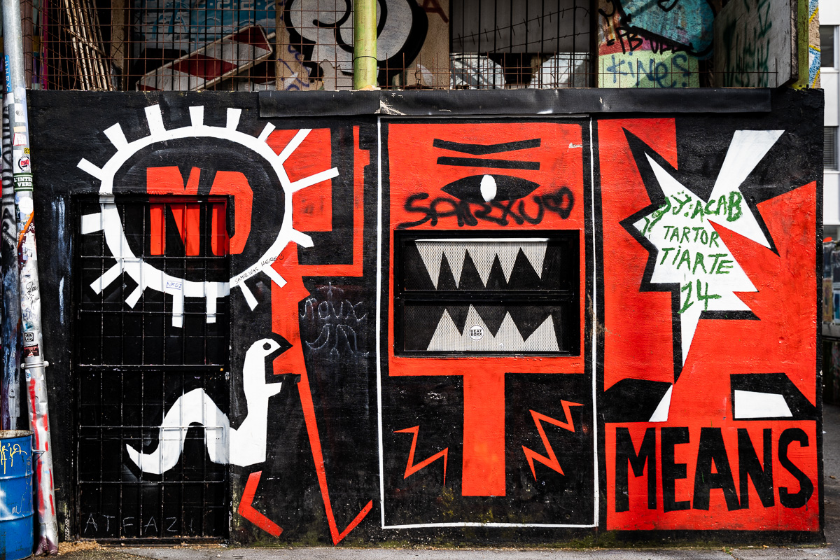 Painted red dumpster integrated into Metelkova street art