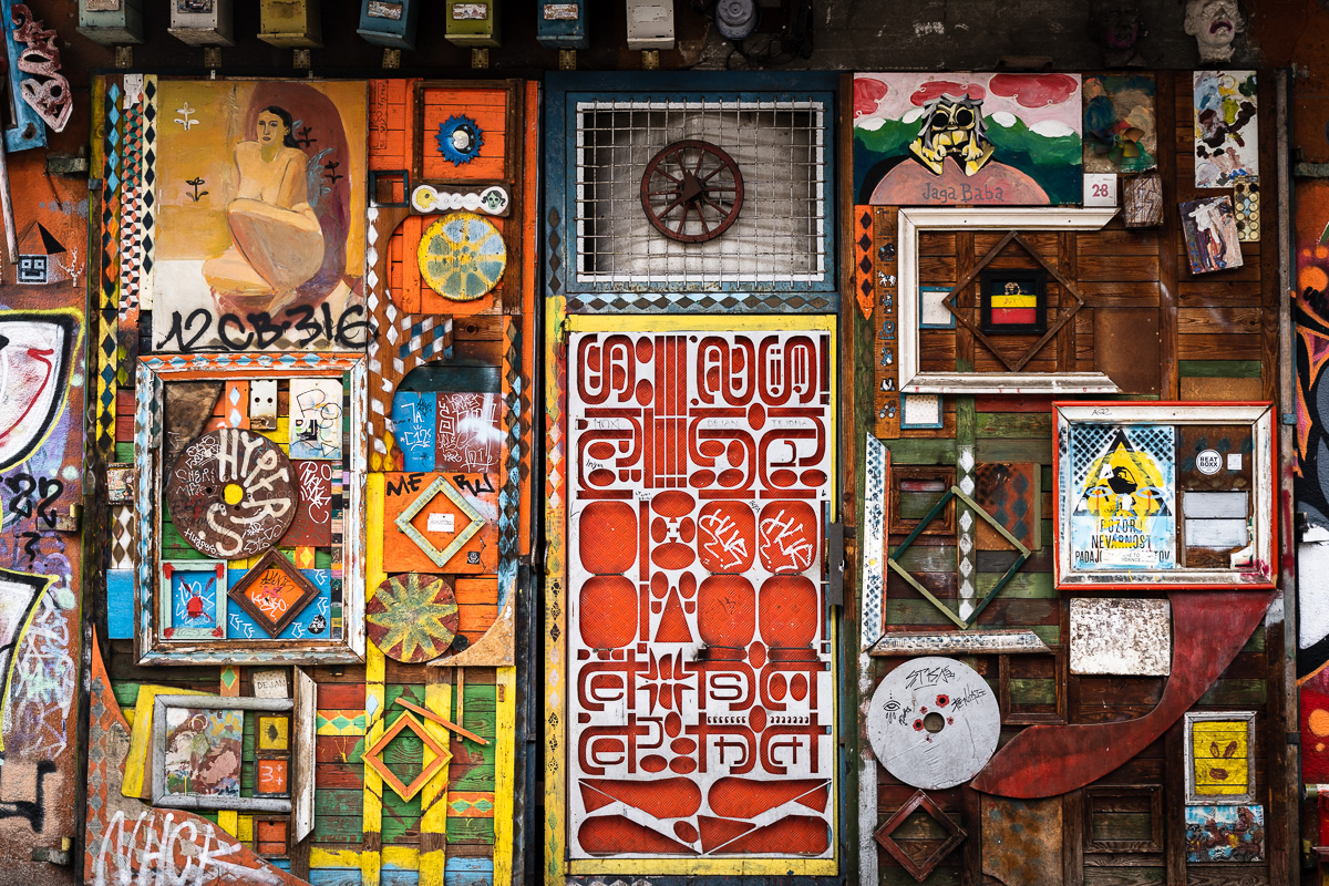 Decorated entrance door covered with painted panels and found objects at Metelkova