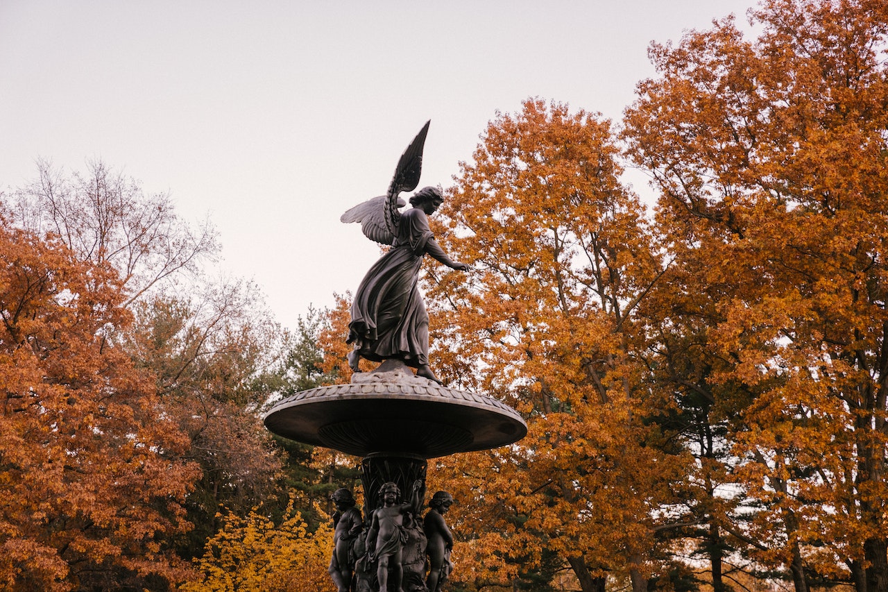 Angel of the Waters at Bethesda Fountain framed by orange autumn trees