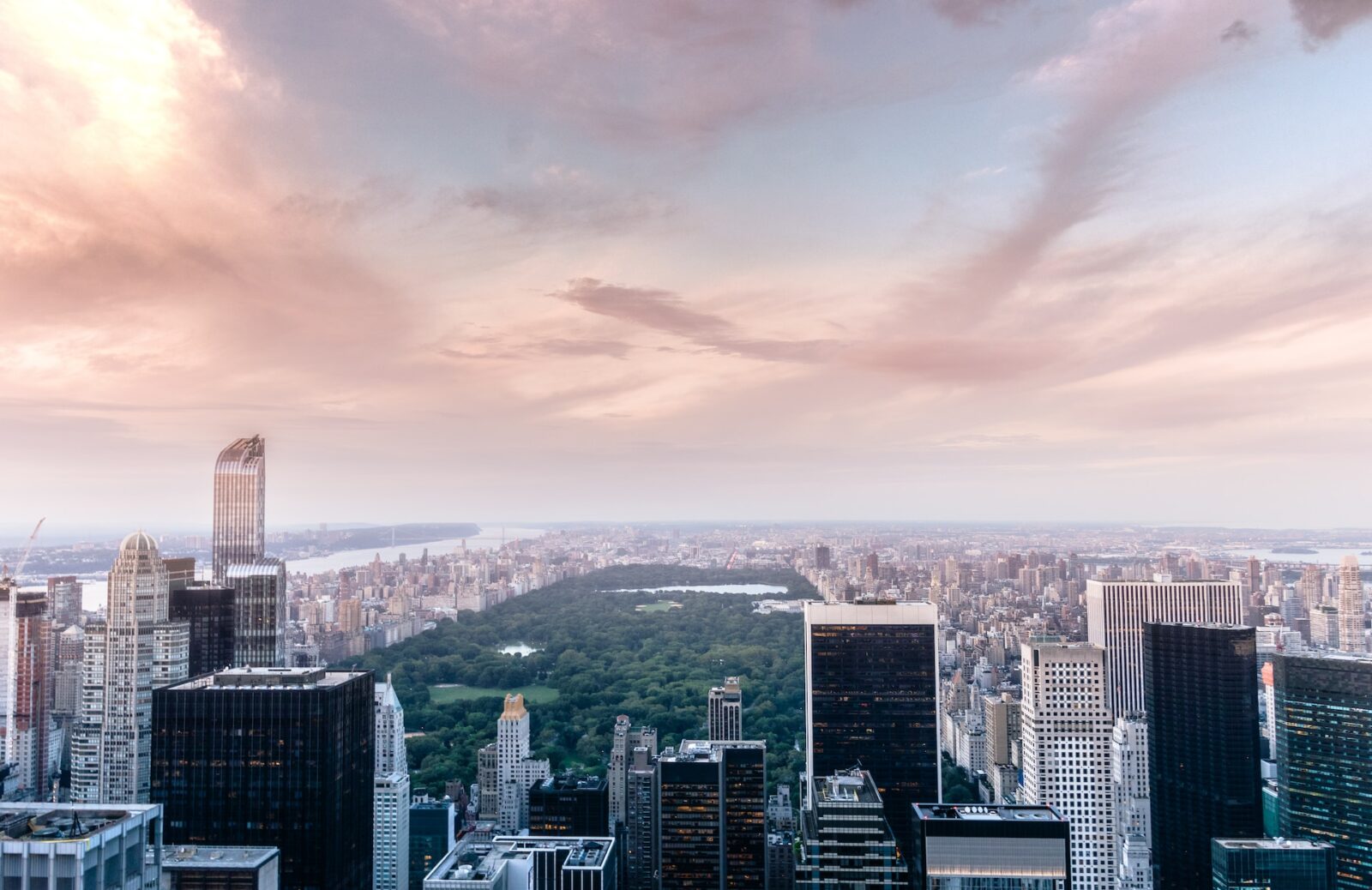Central Park seen from above at sunset, surrounded by Midtown Manhattan skyscrapers