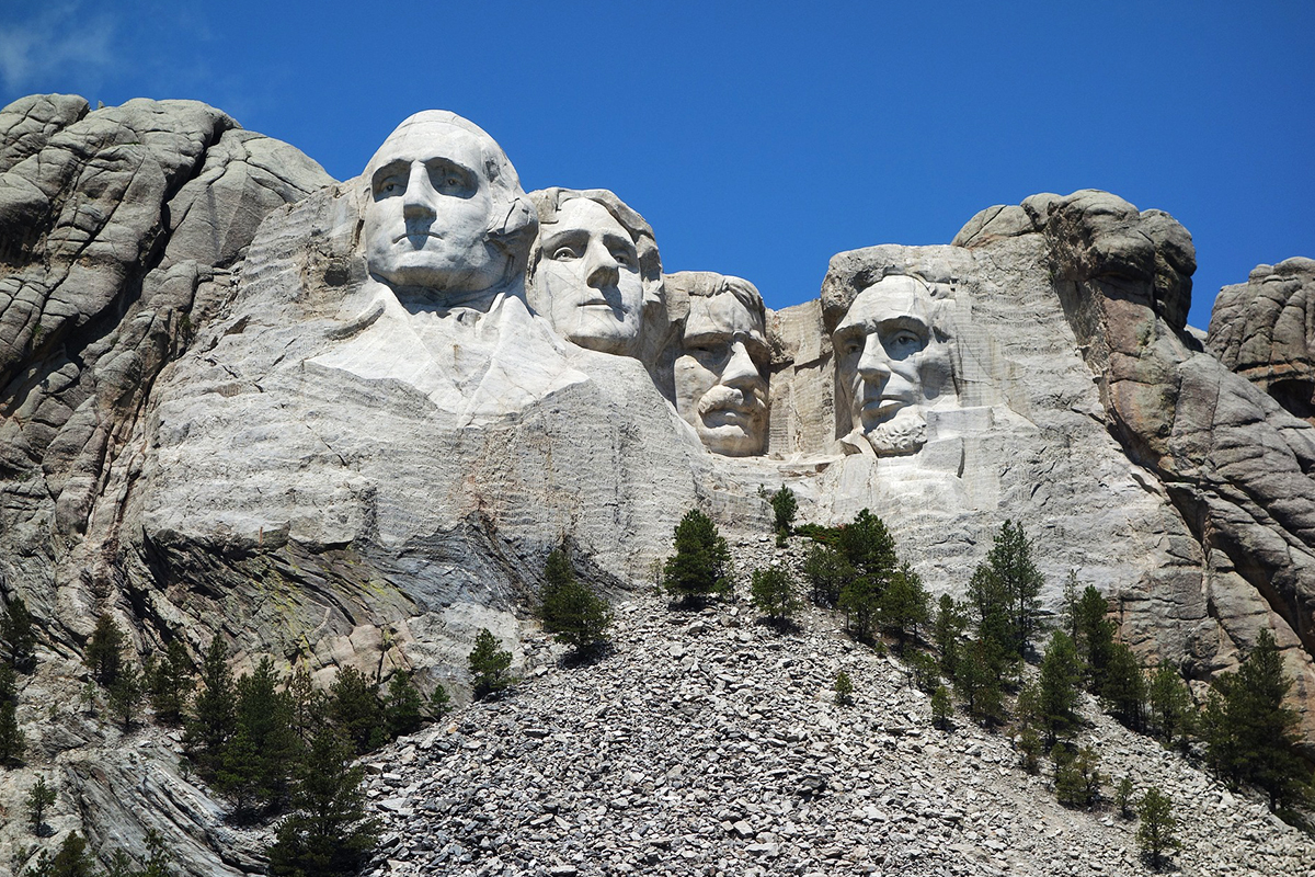 Clear frontal view of all four presidential faces carved into Mount Rushmore