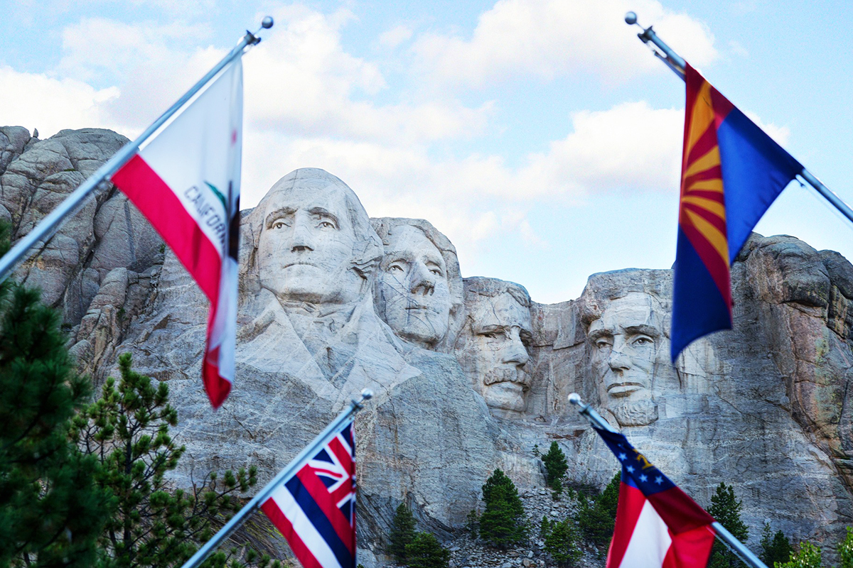 State and territorial flags in the foreground below the Mount Rushmore sculpture