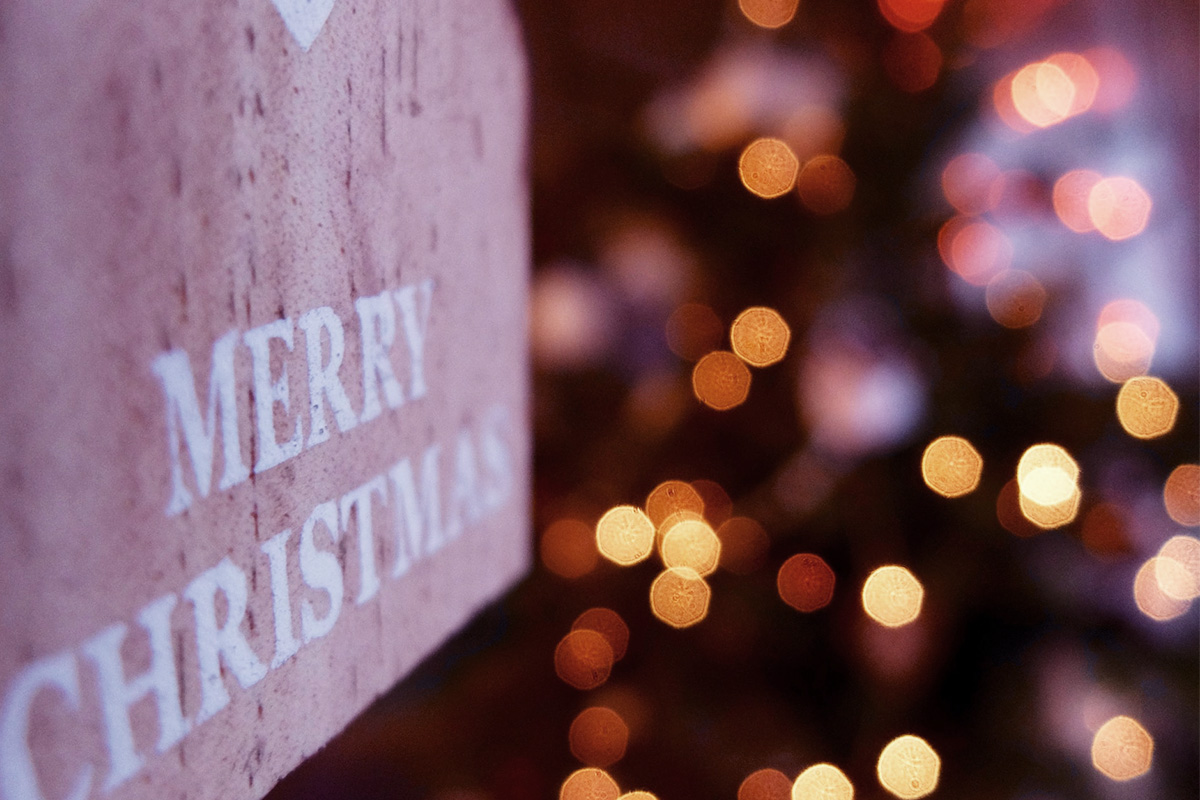 A Christmas sign beside circles of defocused coloured light