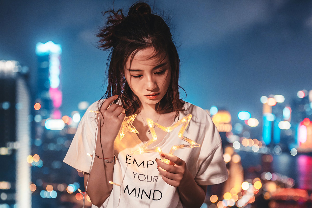 A portrait made against a distant, softly rendered city background
